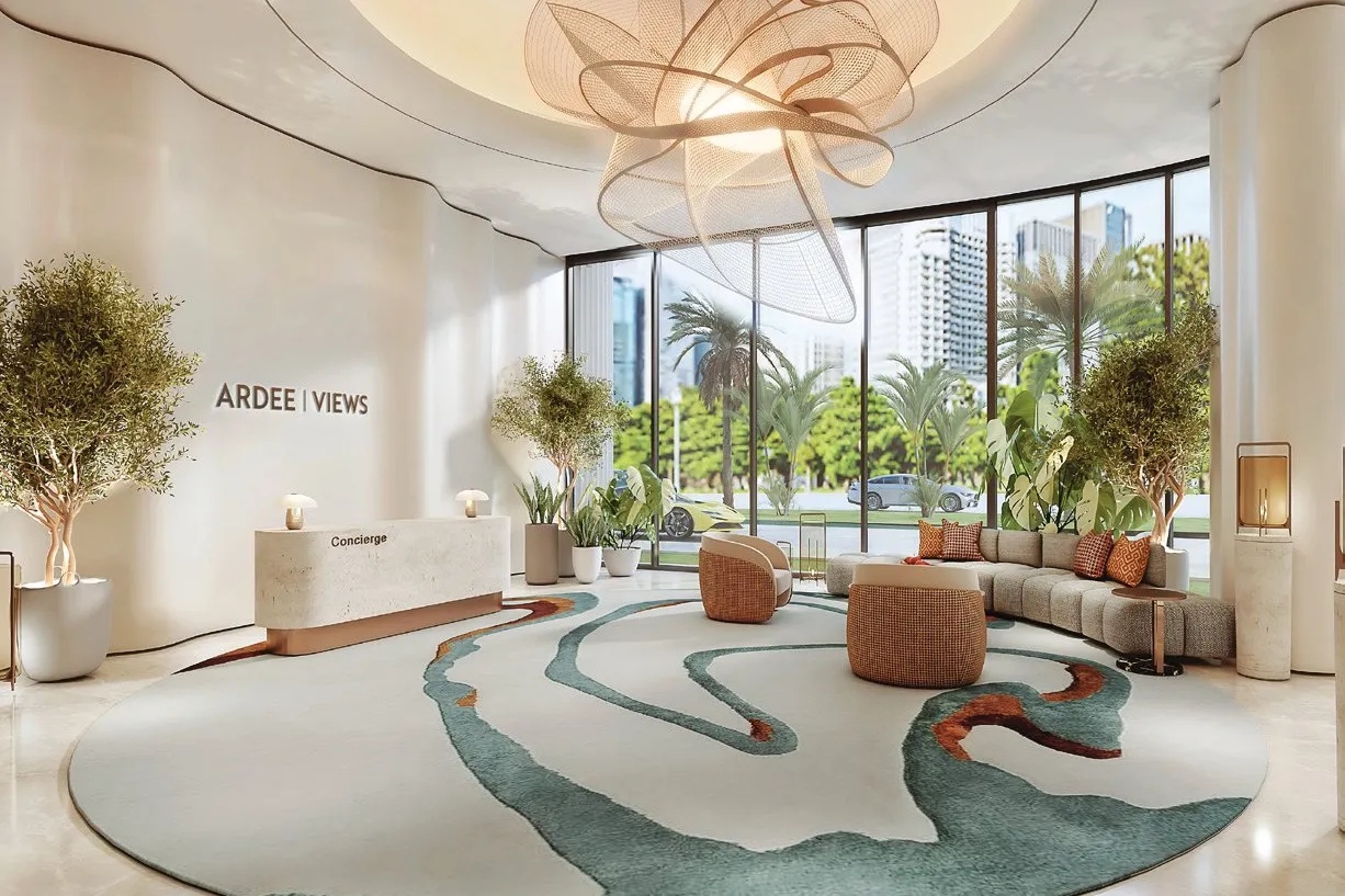 Bright lobby with sculptural ceiling light, concierge desk and garden views